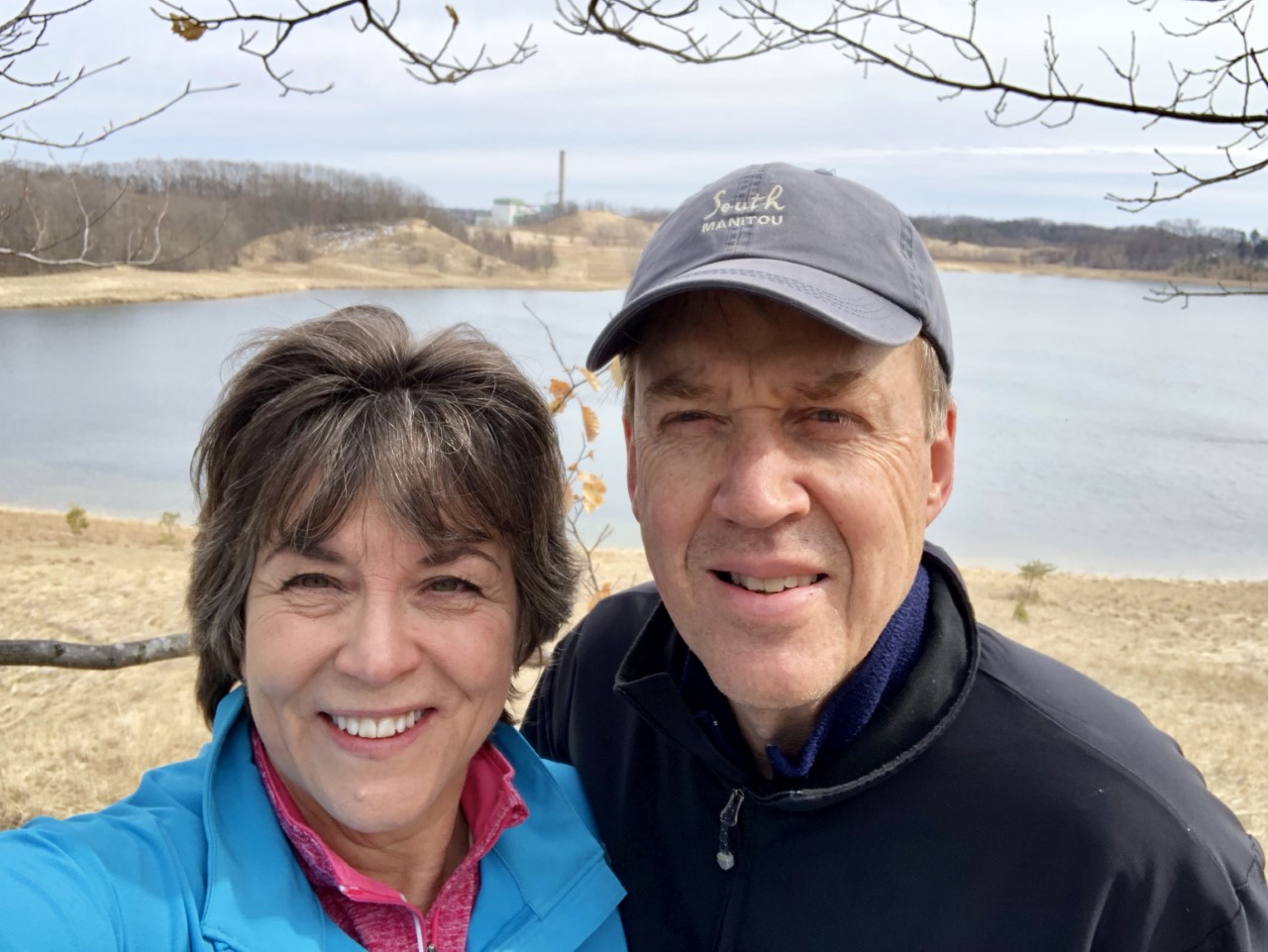 April Scholtz and her husband John stand before a lake at Ottawa Sands County Park
