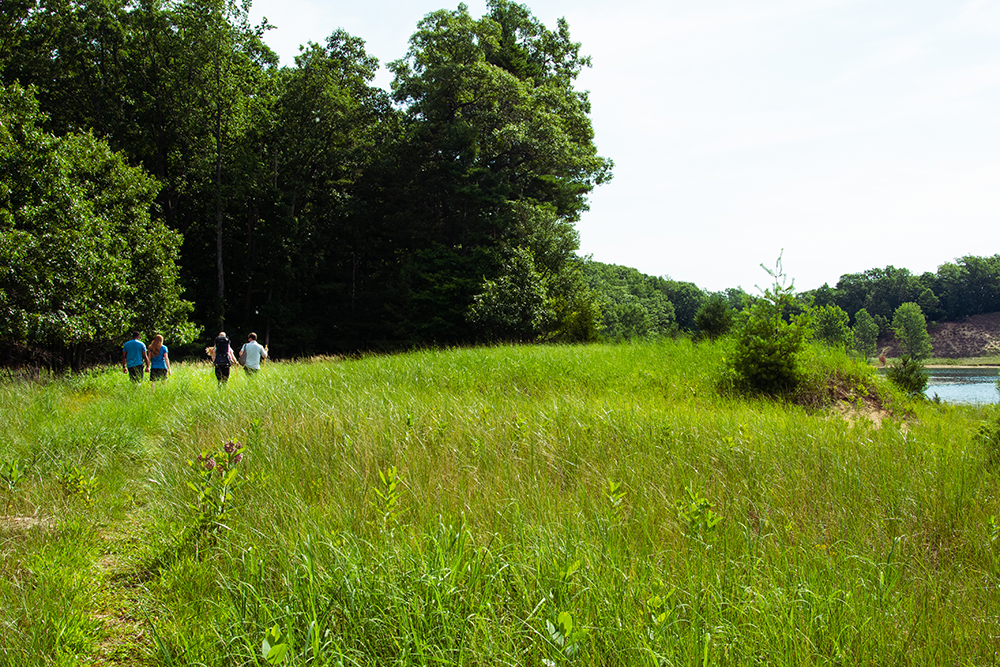 Four adults and a young child walk the trails at Dune Harbor County Park.